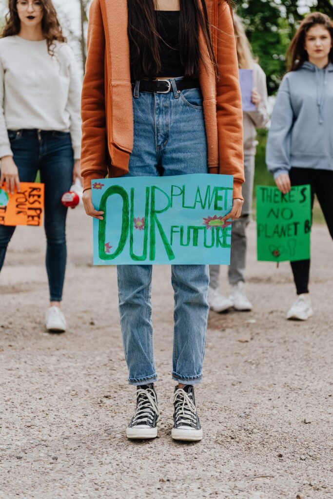 Woman holding sign that says "Our Planet, Our Future"