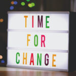 Light up sign that says "Time for Change" in yellow, red, green, and purple letters.